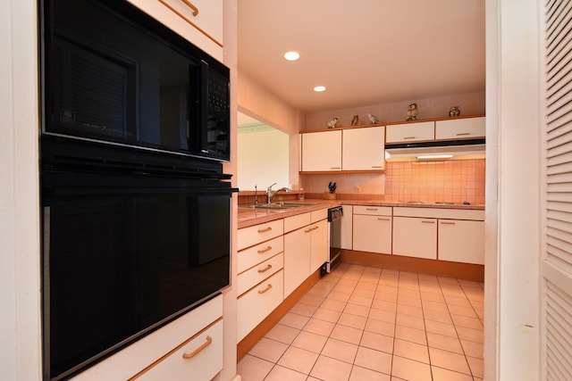 kitchen with sink, white cabinets, backsplash, black appliances, and light tile patterned floors