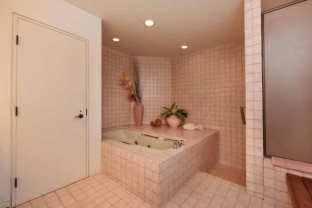 bathroom featuring plus walk in shower, tile patterned flooring, and tile walls