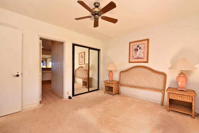 unfurnished bedroom with ceiling fan, a closet, and light carpet