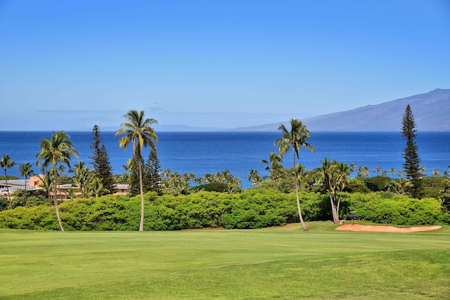 view of property's community featuring a lawn and a water and mountain view