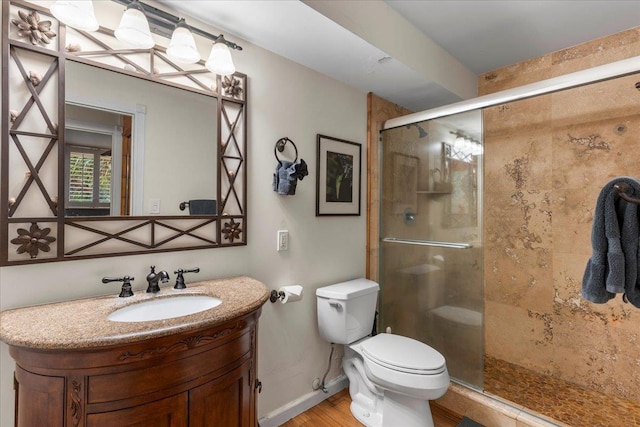 bathroom featuring vanity, wood-type flooring, toilet, and walk in shower