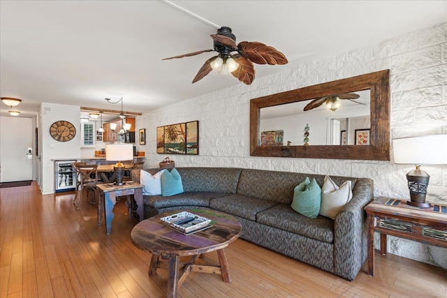 living room featuring wine cooler, hardwood / wood-style floors, and a notable chandelier