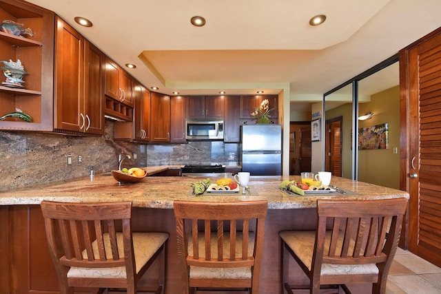 kitchen featuring light stone countertops, tasteful backsplash, stainless steel appliances, sink, and light tile patterned floors