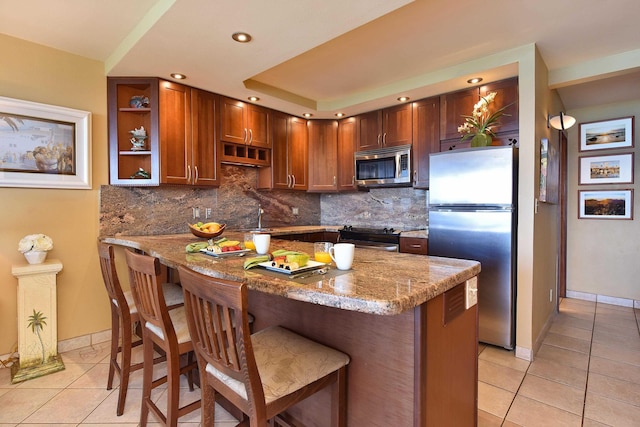 kitchen featuring sink, stainless steel appliances, light stone counters, backsplash, and light tile patterned floors