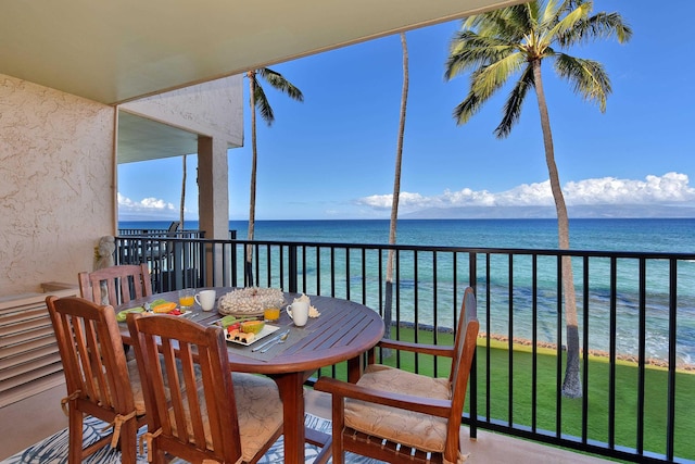 balcony featuring a view of the beach and a water view