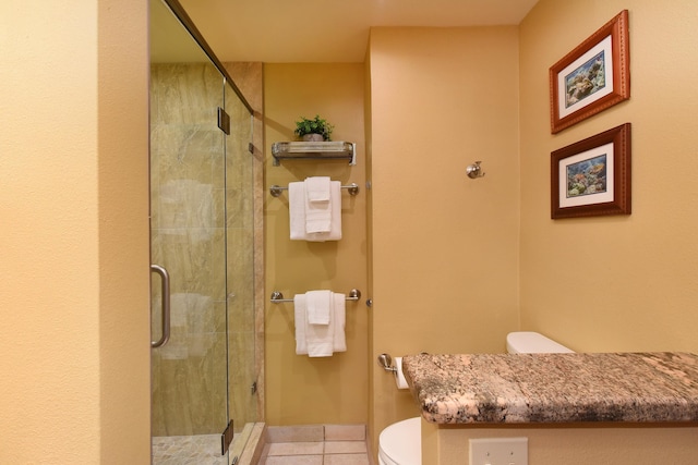 bathroom featuring tile patterned floors, an enclosed shower, and toilet