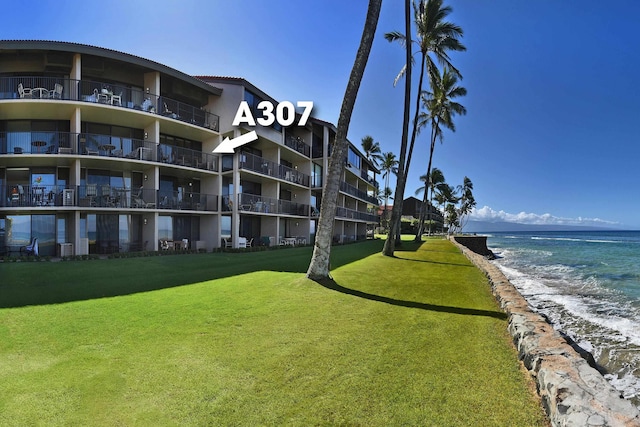 view of building exterior with a beach view and a water view