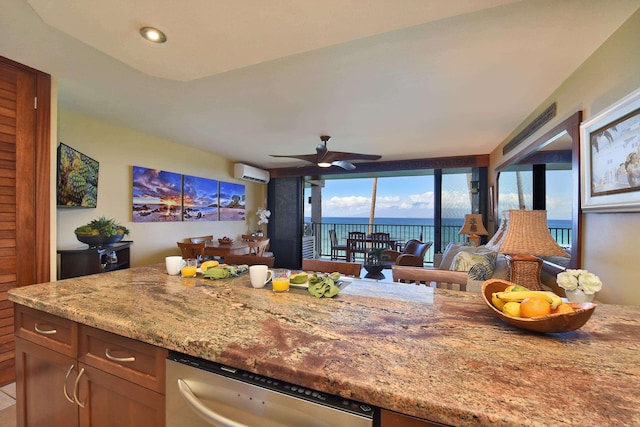 kitchen featuring light stone counters, a wall unit AC, ceiling fan, a water view, and dishwasher