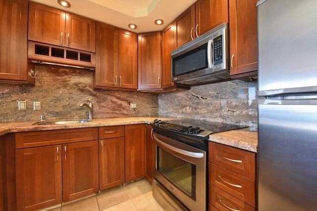 kitchen with decorative backsplash, appliances with stainless steel finishes, light stone countertops, and light tile patterned flooring