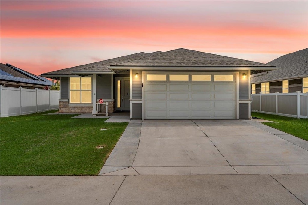 prairie-style home featuring a garage and a yard