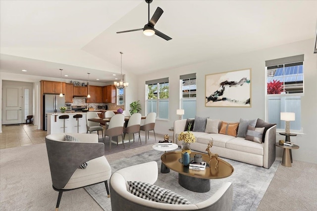 living room featuring ceiling fan with notable chandelier, light colored carpet, and lofted ceiling