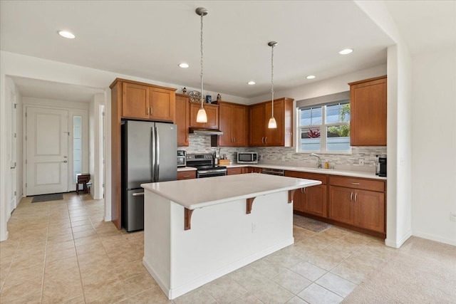 kitchen with a center island, light tile patterned flooring, a breakfast bar, pendant lighting, and appliances with stainless steel finishes