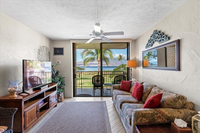 living room featuring a textured ceiling and ceiling fan