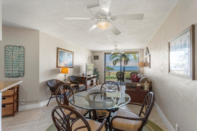 dining space featuring a textured ceiling, ceiling fan, and light tile patterned flooring