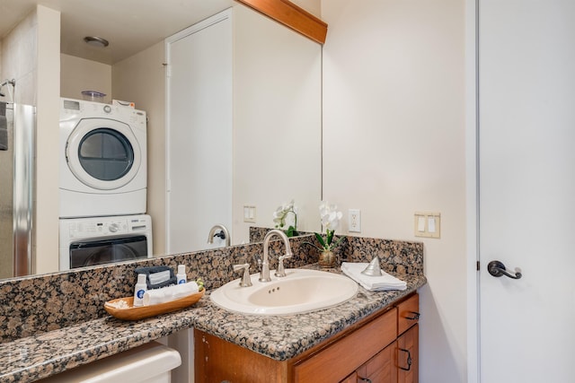 laundry area with light wood-type flooring, ceiling fan, and stacked washer and clothes dryer