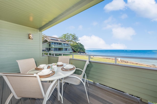 balcony with a water view and a view of the beach