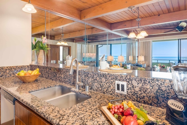 kitchen with dishwasher, sink, a water view, a chandelier, and beamed ceiling