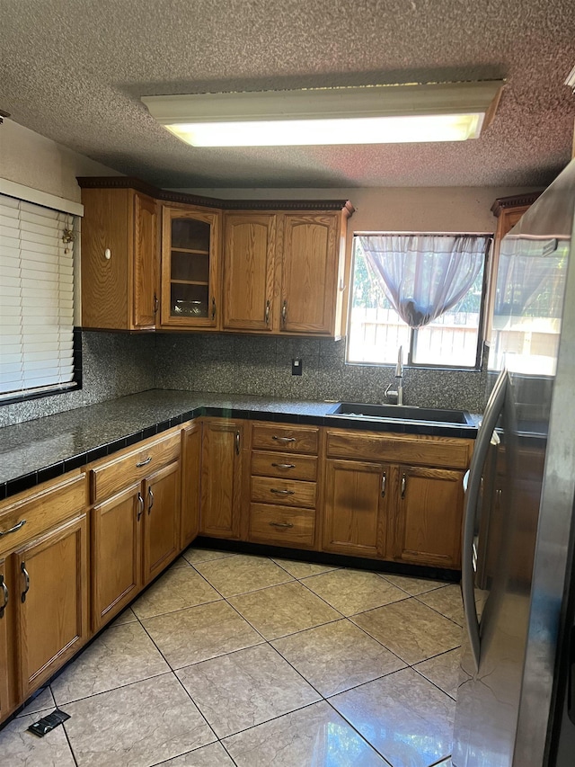 kitchen featuring brown cabinetry, tasteful backsplash, and a sink