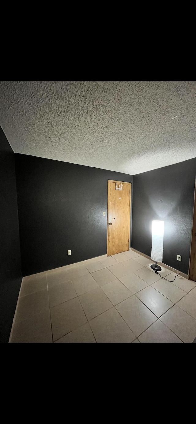 interior space featuring tile patterned flooring and a textured ceiling