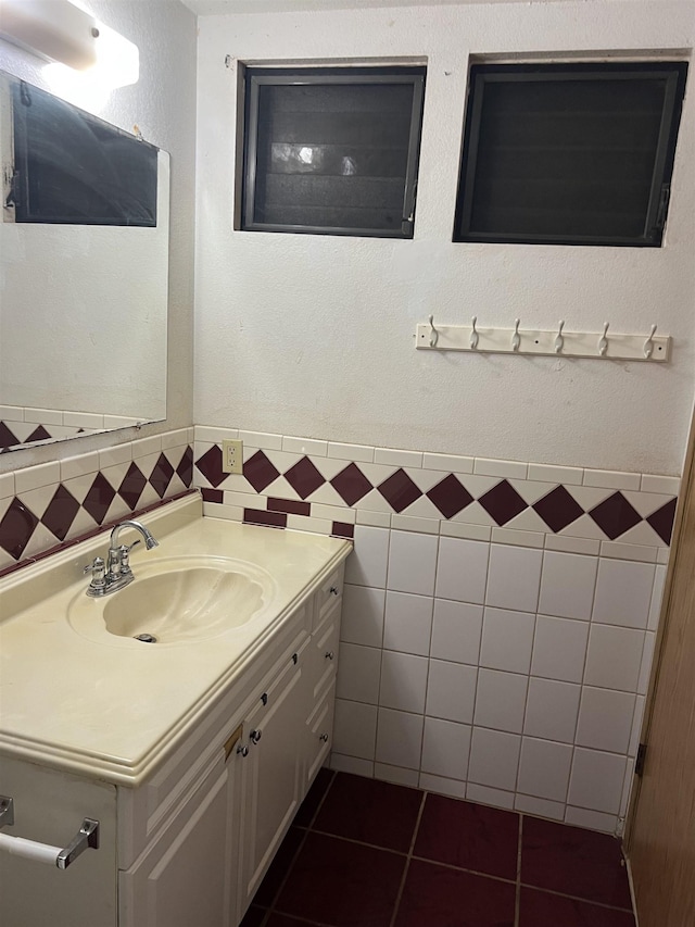 bathroom with tile patterned floors, wainscoting, tile walls, and vanity