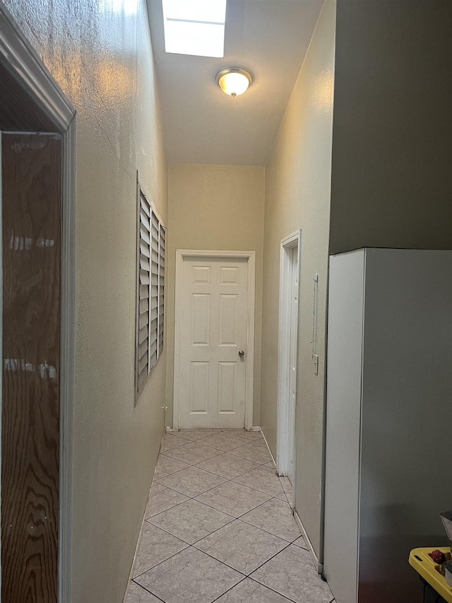 hall featuring light tile patterned floors