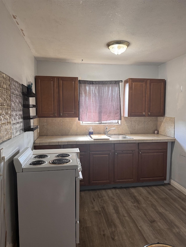 kitchen with tasteful backsplash, dark wood finished floors, tile countertops, white electric range oven, and a sink