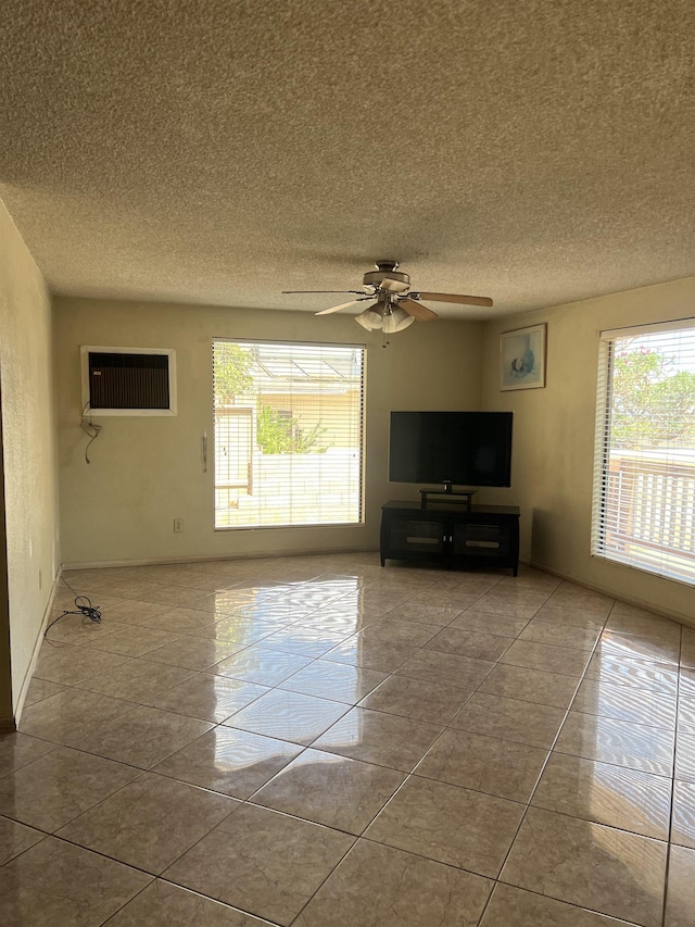 unfurnished living room with tile patterned floors, a textured ceiling, ceiling fan, and a wall unit AC