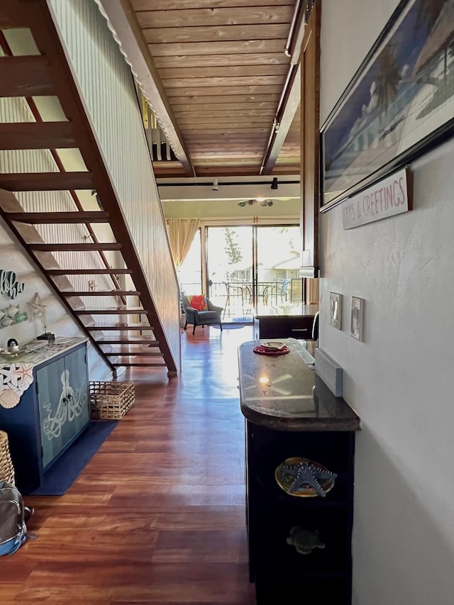 hallway featuring dark wood-type flooring, beam ceiling, and wood ceiling