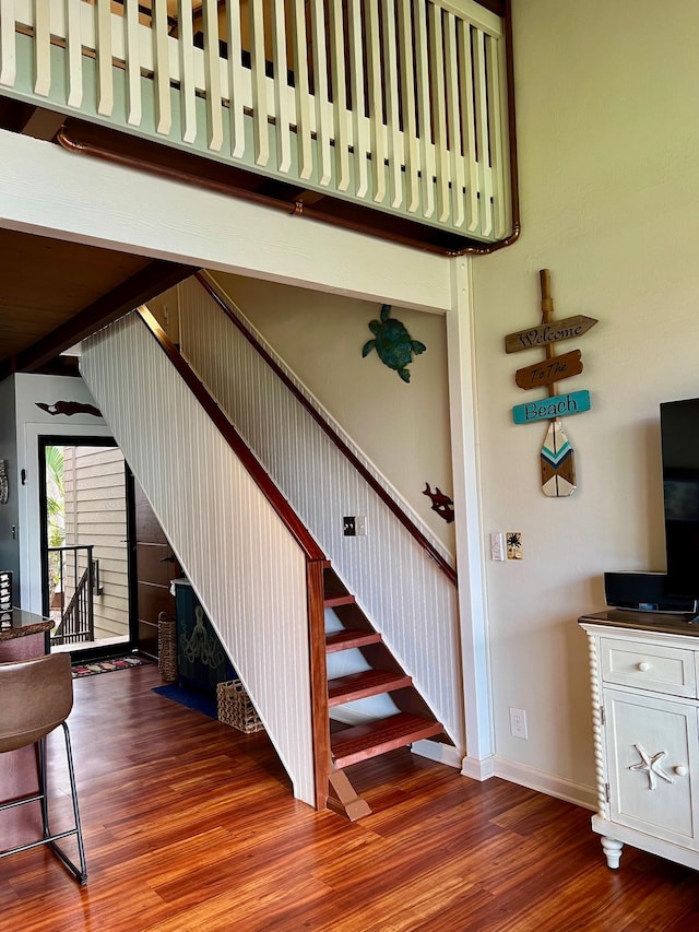 stairs featuring a high ceiling and wood-type flooring