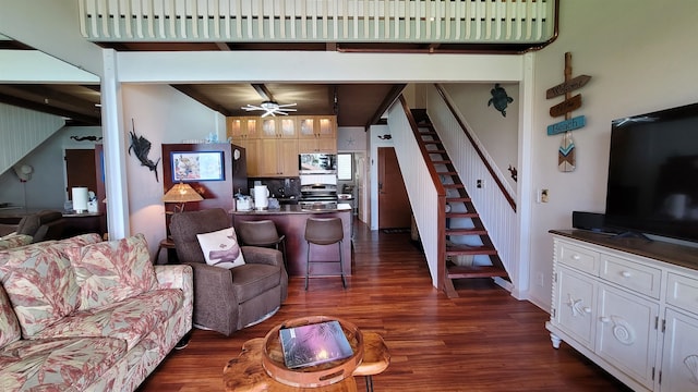 living room with beam ceiling, dark hardwood / wood-style flooring, and ceiling fan