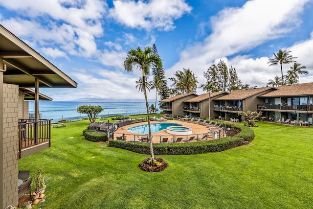 view of pool featuring a water view and a yard