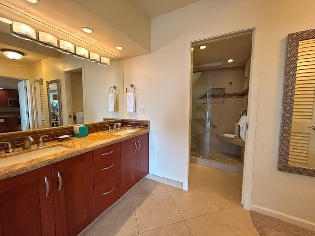 bathroom with dual sinks, tile flooring, large vanity, and a shower with door