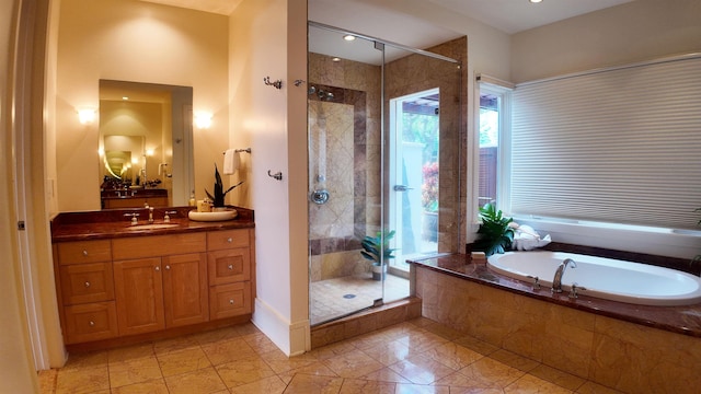 full bath with a shower stall, vanity, and a bath