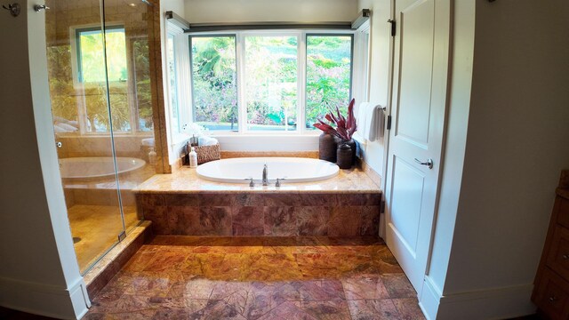 full bath featuring a stall shower and a garden tub