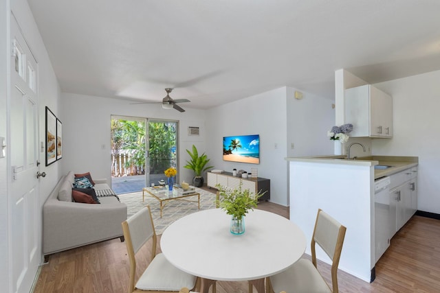 dining space featuring sink, light wood-type flooring, and ceiling fan