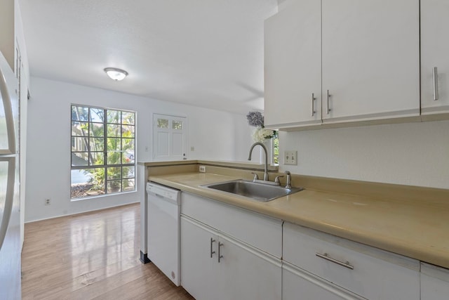 kitchen with white cabinets, dishwasher, light hardwood / wood-style floors, and sink