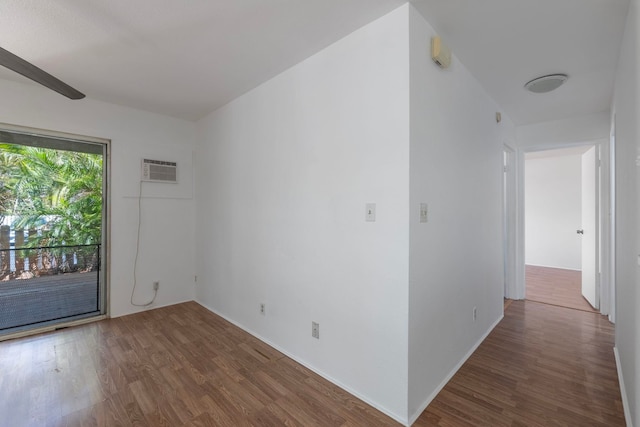 spare room featuring an AC wall unit and dark hardwood / wood-style flooring