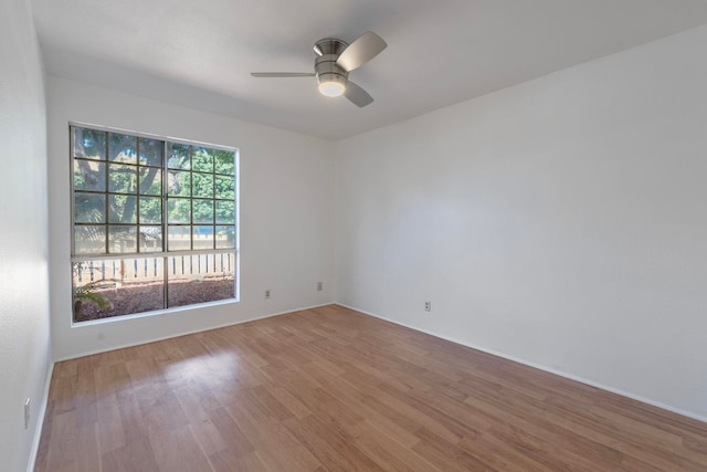 empty room with hardwood / wood-style floors and ceiling fan