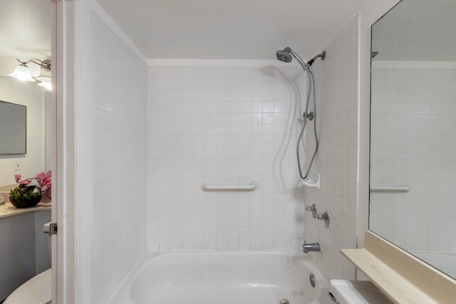 bathroom featuring tiled shower / bath combo and toilet