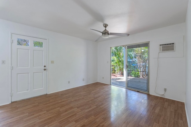 empty room with ceiling fan, hardwood / wood-style floors, and a wall mounted AC