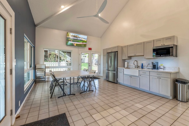 kitchen featuring high vaulted ceiling, stainless steel appliances, gray cabinetry, sink, and light tile patterned floors