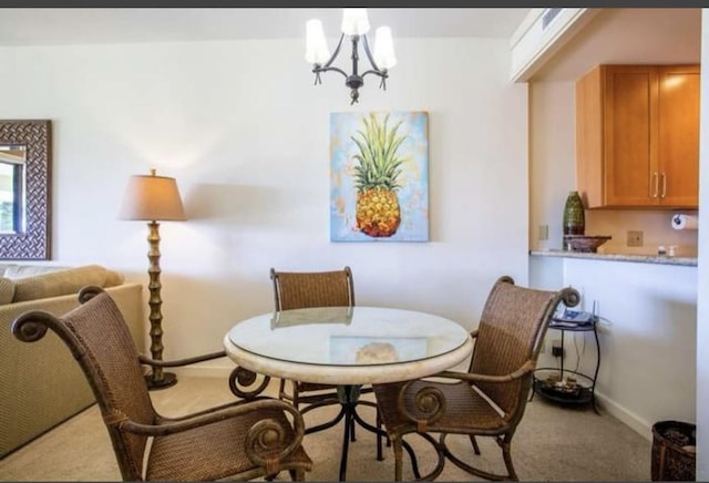 dining area featuring light colored carpet and an inviting chandelier