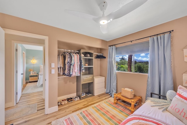 bedroom with light hardwood / wood-style flooring, a closet, and ceiling fan