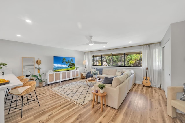 living room with ceiling fan and light wood-type flooring