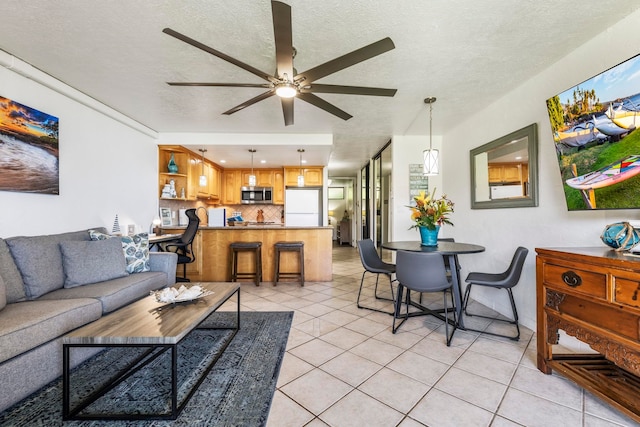 tiled living room with ceiling fan and a textured ceiling