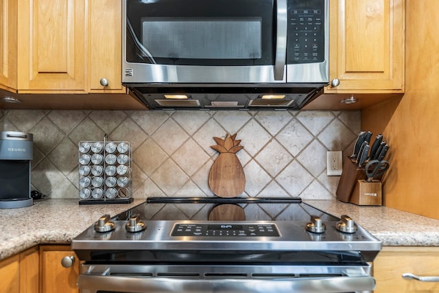 kitchen featuring stainless steel appliances, tasteful backsplash, mail boxes, and light stone counters