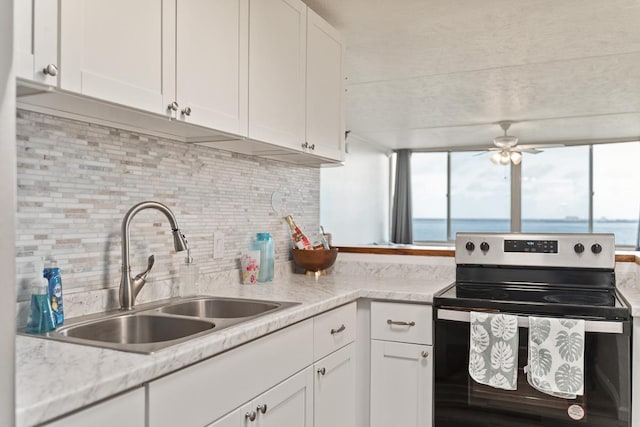 kitchen with white cabinetry, a healthy amount of sunlight, stainless steel electric range, and a sink