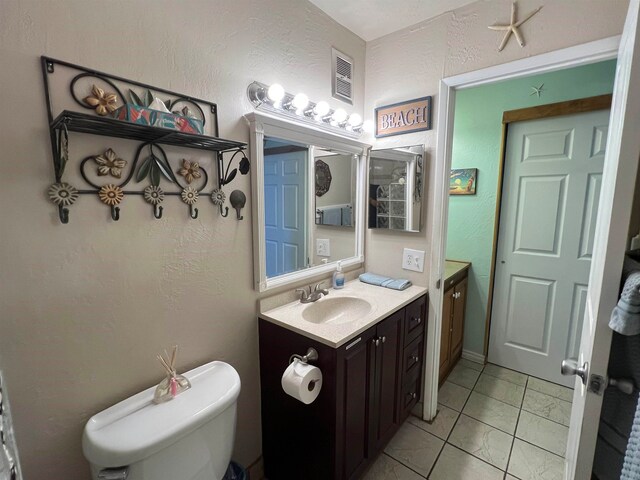 bathroom featuring vanity, toilet, and tile patterned flooring