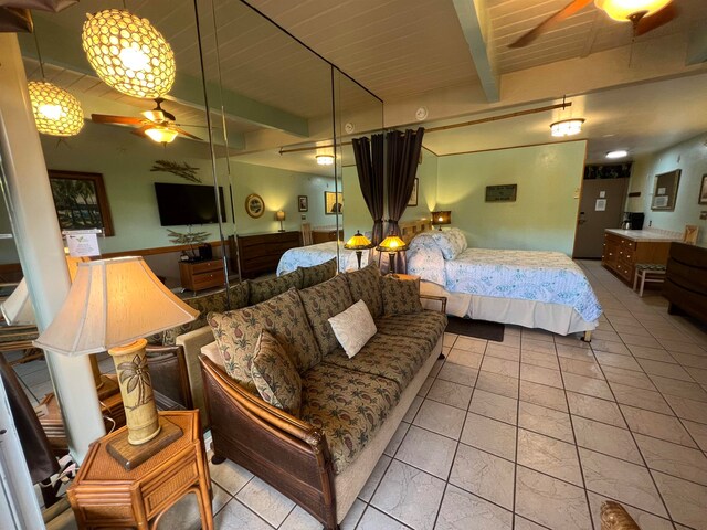 bedroom featuring beamed ceiling and light tile patterned flooring