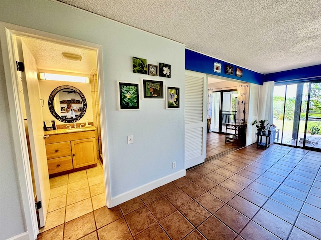 hallway with tile patterned flooring and a textured ceiling